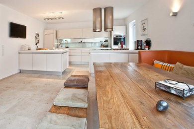 Große Moderne Wohnküche mit flächenbündigen Schrankfronten, weißen Schränken, Glasrückwand, Küchengeräten aus Edelstahl, Halbinsel, Küchenrückwand in Weiß und Travertin in Frankfurt am Main