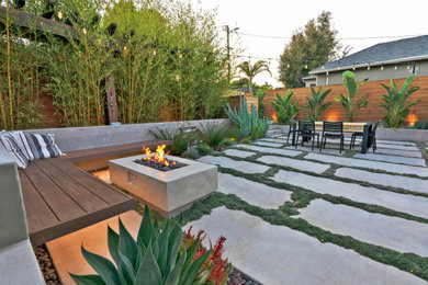 Modelo de patio moderno de tamaño medio en patio trasero con brasero y losas de hormigón