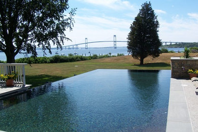 This is an example of a mid-sized transitional full sun backyard concrete paver water fountain landscape in Providence for summer.