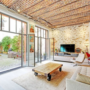 Großes, Offenes Mediterranes Wohnzimmer mit hellem Holzboden, beiger Wandfarbe, freistehendem TV und beigem Boden in Paris