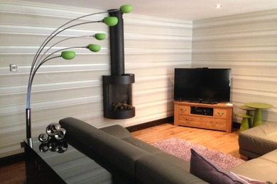 This is an example of a contemporary enclosed living room in Other with a hanging fireplace.
