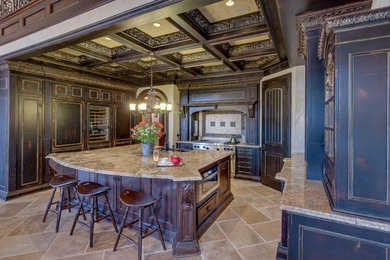 Large traditional u-shaped eat-in kitchen in Detroit with a farmhouse sink, recessed-panel cabinets, distressed cabinets, granite benchtops, beige splashback, panelled appliances, travertine floors, with island, beige floor and stone tile splashback.