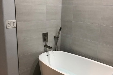 Corner bathtub - large contemporary gray tile and cement tile beige floor corner bathtub idea in Los Angeles with gray walls, solid surface countertops, a hinged shower door and white countertops