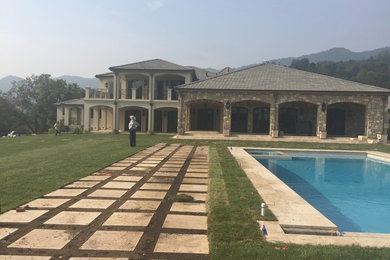Diseño de piscina mediterránea grande en patio trasero