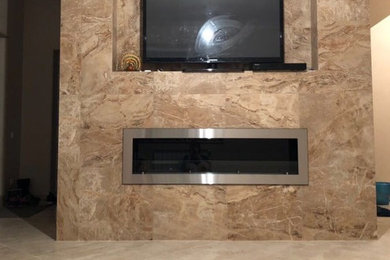 Стильный дизайн: большая открытая гостиная комната с коричневыми стенами, горизонтальным камином, фасадом камина из металла, телевизором на стене и бежевым полом - последний тренд
