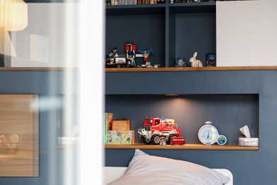 Modelo de dormitorio infantil de 4 a 10 años de tamaño medio con paredes azules y suelo de madera clara