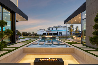 Example of a large minimalist backyard tile and rectangular pool design in Dallas