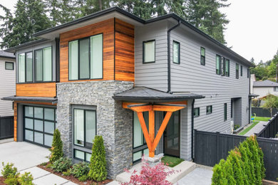 Imagen de fachada de casa pareada gris y negra minimalista grande de dos plantas con revestimientos combinados, tejado plano, tejado de metal y panel y listón
