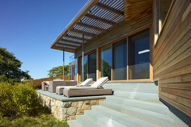 Example of a trendy backyard deck design in Boston with a pergola