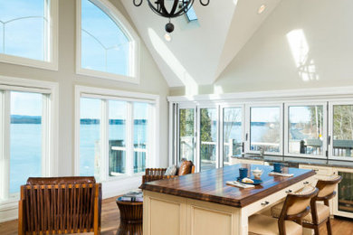 Large mountain style medium tone wood floor and vaulted ceiling eat-in kitchen photo in Other with a single-bowl sink, glass-front cabinets, medium tone wood cabinets, white backsplash, stainless steel appliances, an island and gray countertops