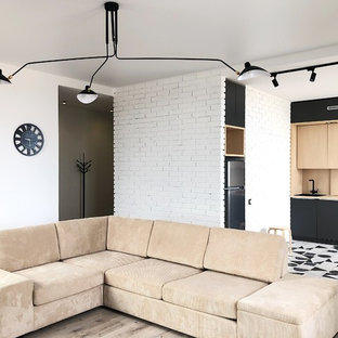 Modern inredning av ett mellanstort vardagsrum, med vita väggar, laminatgolv och vitt golv