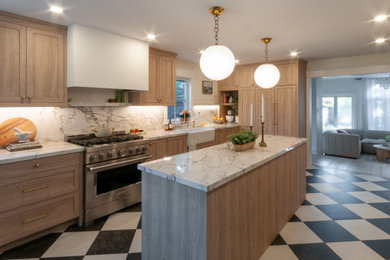 Example of a mid-sized transitional galley porcelain tile and multicolored floor eat-in kitchen design in Toronto with a farmhouse sink, shaker cabinets, light wood cabinets, solid surface countertops, white backsplash, stone slab backsplash, paneled appliances, an island and white countertops
