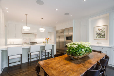 Eat-in kitchen - mid-sized transitional single-wall dark wood floor and brown floor eat-in kitchen idea in Atlanta with an undermount sink, white cabinets, marble countertops, white backsplash, stainless steel appliances, a peninsula, recessed-panel cabinets and subway tile backsplash
