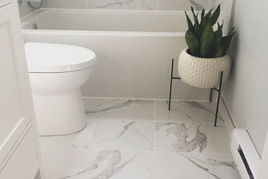 Bathroom - small contemporary master white tile and ceramic tile ceramic tile and white floor bathroom idea in Montreal with shaker cabinets, white cabinets, a one-piece toilet, gray walls, a drop-in sink, marble countertops and white countertops