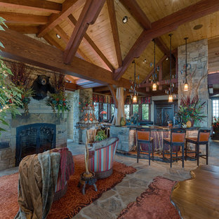 シャーロットの大きいラスティックスタイルのおしゃれな着席型バー (アンダーカウンターシンク、落し込みパネル扉のキャビネット、濃色木目調キャビネット、木材カウンター、スレートの床、グレーの床、茶色いキッチンカウンター) の写真