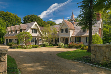 Large traditional three-storey beige house exterior in Boston with wood siding and a gable roof.