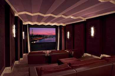 Photo of an expansive contemporary enclosed home theatre in Los Angeles with red walls, carpet, a built-in media wall and red floor.