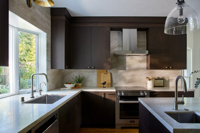 Inspiration for a mid-sized transitional u-shaped medium tone wood floor and brown floor enclosed kitchen remodel in Sacramento with a single-bowl sink, flat-panel cabinets, dark wood cabinets, quartzite countertops, beige backsplash, stone slab backsplash, stainless steel appliances, an island and beige countertops