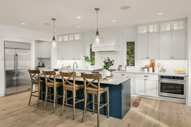 Inspiration for a kitchen remodel in Seattle with white cabinets and an island