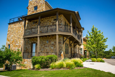 Inspiration for a huge transitional beige three-story stone exterior home remodel in Austin with a hip roof