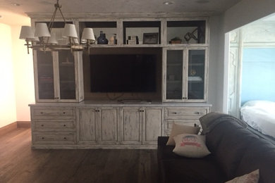 Inspiration for a timeless light wood floor family room remodel in Other with a wall-mounted tv
