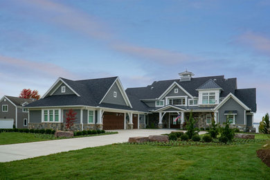 Large tuscan gray two-story vinyl and shingle house exterior photo in Other with a mixed material roof and a black roof
