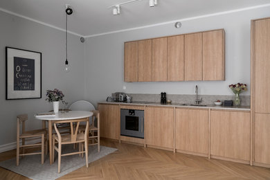 Kitchen in Stockholm with light wood cabinets and grey benchtop.