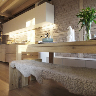 Große Skandinavische Küche in U-Form mit Vorratsschrank, integriertem Waschbecken, Glasfronten, dunklen Holzschränken, Arbeitsplatte aus Fliesen, Küchenrückwand in Blau, Rückwand aus Glasfliesen, Elektrogeräten mit Frontblende, braunem Holzboden, zwei Kücheninseln und braunem Boden in Sonstige