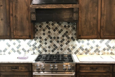 Large mountain style medium tone wood floor kitchen photo in Dallas with a farmhouse sink, shaker cabinets, dark wood cabinets, granite countertops, multicolored backsplash, porcelain backsplash, stainless steel appliances, an island and white countertops