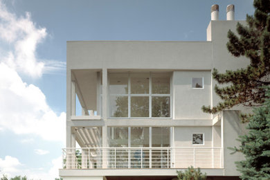 Example of a large trendy white four-story stucco exterior home design in Cincinnati