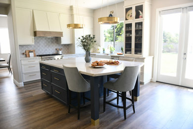 Large elegant u-shaped vinyl floor and brown floor open concept kitchen photo in San Diego with a farmhouse sink, shaker cabinets, beige cabinets, quartzite countertops, blue backsplash, limestone backsplash, paneled appliances, an island and beige countertops