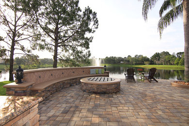 Example of a mid-sized transitional backyard concrete paver patio kitchen design in Orlando with no cover
