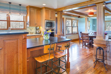 Eat-in kitchen - mid-sized traditional galley medium tone wood floor eat-in kitchen idea in Other with medium tone wood cabinets and stainless steel appliances