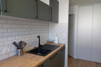 Foto de cocina moderna pequeña abierta con fregadero encastrado, puertas de armario verdes, encimera de laminado, salpicadero blanco, salpicadero de azulejos tipo metro y suelo laminado