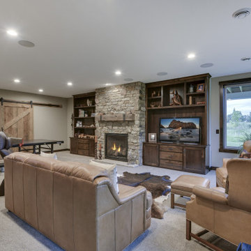 Reclaimed Wood Mantel with Metal Straps on Light Stone Fireplace in Basement