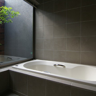 Esempio di una stanza da bagno minimalista con vasca ad angolo e pavimento grigio