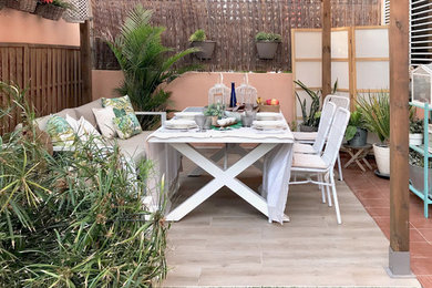 Foto de patio actual pequeño en patio trasero con suelo de baldosas y pérgola