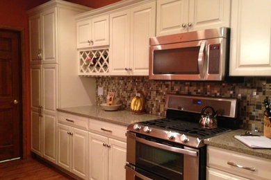 Example of a large transitional l-shaped medium tone wood floor eat-in kitchen design in Chicago with an undermount sink, raised-panel cabinets, white cabinets, quartz countertops, multicolored backsplash, mosaic tile backsplash, stainless steel appliances and no island
