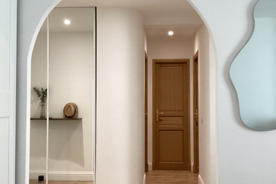 Aménagement d'un couloir méditerranéen de taille moyenne avec un mur blanc et sol en stratifié.