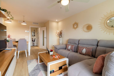 Foto de salón abierto y blanco y madera tradicional renovado de tamaño medio con paredes beige, suelo laminado, televisor independiente y alfombra