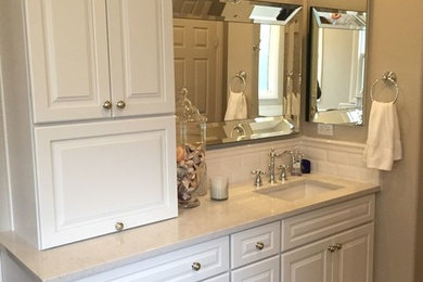 Inspiration for a mid-sized traditional 3/4 bathroom in San Diego with raised-panel cabinets, white cabinets, beige walls, medium hardwood floors, an undermount sink, granite benchtops and brown floor.