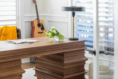 Inspiration for a large modern freestanding desk medium tone wood floor study room remodel in Denver with white walls