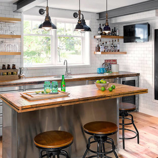 デンバーのインダストリアルスタイルのおしゃれなホームバー (ドロップインシンク、フラットパネル扉のキャビネット、白いキッチンパネル、サブウェイタイルのキッチンパネル、無垢フローリング、茶色いキッチンカウンター) の写真