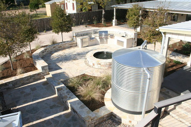 Patio fountain - industrial backyard stone patio fountain idea in Austin