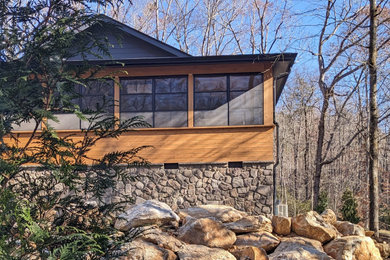 This is an example of a mid-sized mid-century modern screened-in front porch design in Other with a roof extension.