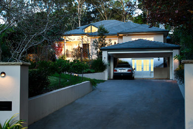 This is an example of a large contemporary two-storey concrete beige house exterior in Sydney with a gable roof and a tile roof.