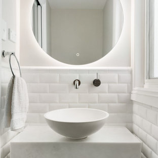 This is an example of a transitional powder room in Sydney with white cabinets, solid surface benchtops, white benchtops and a floating vanity.