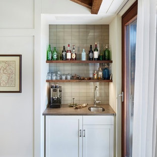 ニューヨークの小さいトランジショナルスタイルのおしゃれなウェットバー (アンダーカウンターシンク、グレーのキッチンパネル、淡色無垢フローリング、シェーカースタイル扉のキャビネット、白いキャビネット、大理石カウンター、ガラスタイルのキッチンパネル、グレーのキッチンカウンター) の写真