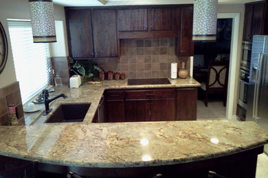 Eat-in kitchen - small traditional galley ceramic tile eat-in kitchen idea in Los Angeles with an undermount sink, flat-panel cabinets, dark wood cabinets, granite countertops, beige backsplash, ceramic backsplash, stainless steel appliances and a peninsula
