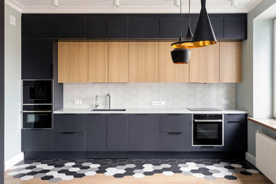 Mid-sized scandinavian single-wall eat-in kitchen in Moscow with an undermount sink, flat-panel cabinets, black cabinets, solid surface benchtops, white splashback, ceramic splashback, black appliances, ceramic floors, no island, white benchtop and multi-coloured floor.